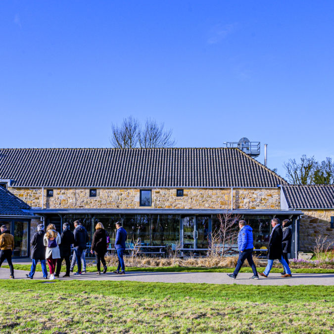 Kingsbarns distillery exterior with visitors entering through glass doors