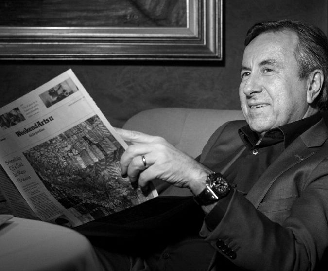 daniel boulud reading a newspaper in black and white