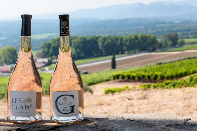 Bottles of Chateau d’Esclans Garrus and Les Clans with the estate in the background