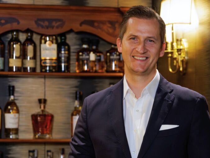 Raimonds Tomsons standing in front of a bar
