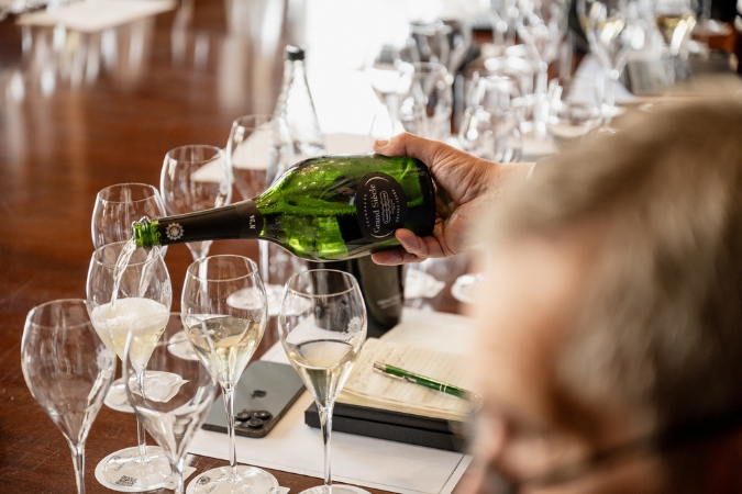 Champagne being poured into glasses on a table for tasting