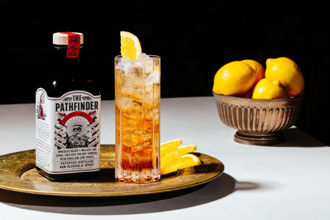 A bottle of The Pathfinder next to a glass of The Pathfinder Spritz