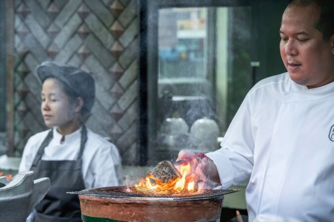 Two chefs working in the kitchen at Sorn restaurant in Bangkok