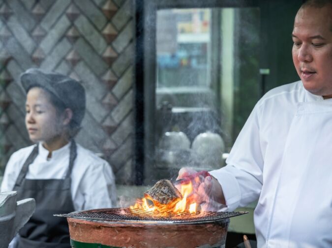 Two chefs working in the kitchen at Sorn restaurant in Bangkok