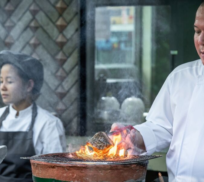Two chefs working in the kitchen at Sorn restaurant in Bangkok