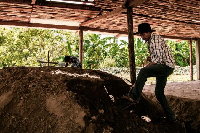 man cooking mezcal underground in oaxaca