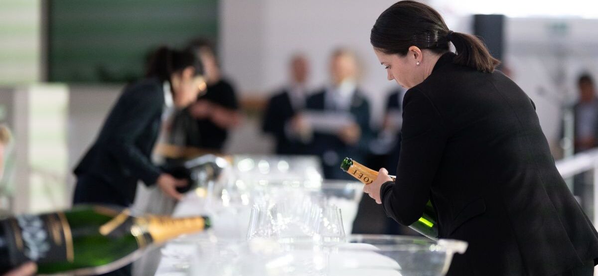 sommelier emma denney pouring wine at uk sommelier of the year competition