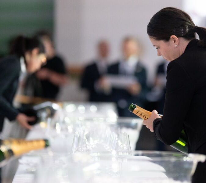 sommelier emma denney pouring wine at uk sommelier of the year competition