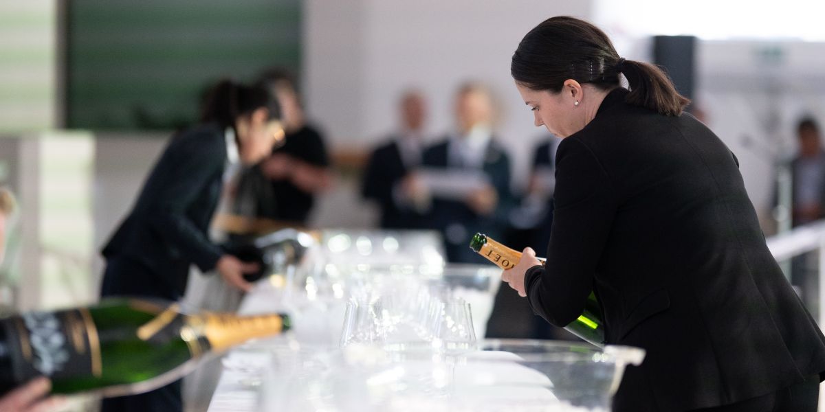 sommelier emma denney pouring wine at uk sommelier of the year competition