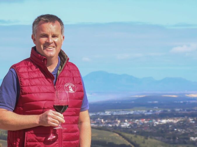 winemaker luke o'cuinneagain with glass of red wine at viewpoint