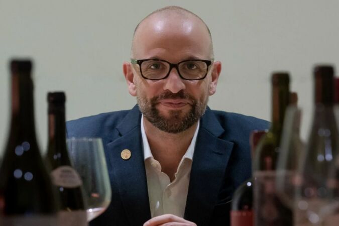 richard hemming mw surrounded by wine bottles