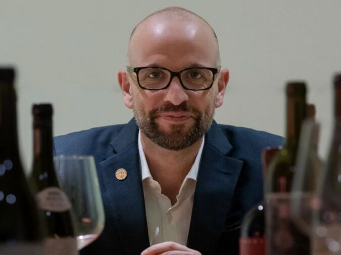 richard hemming mw surrounded by wine bottles