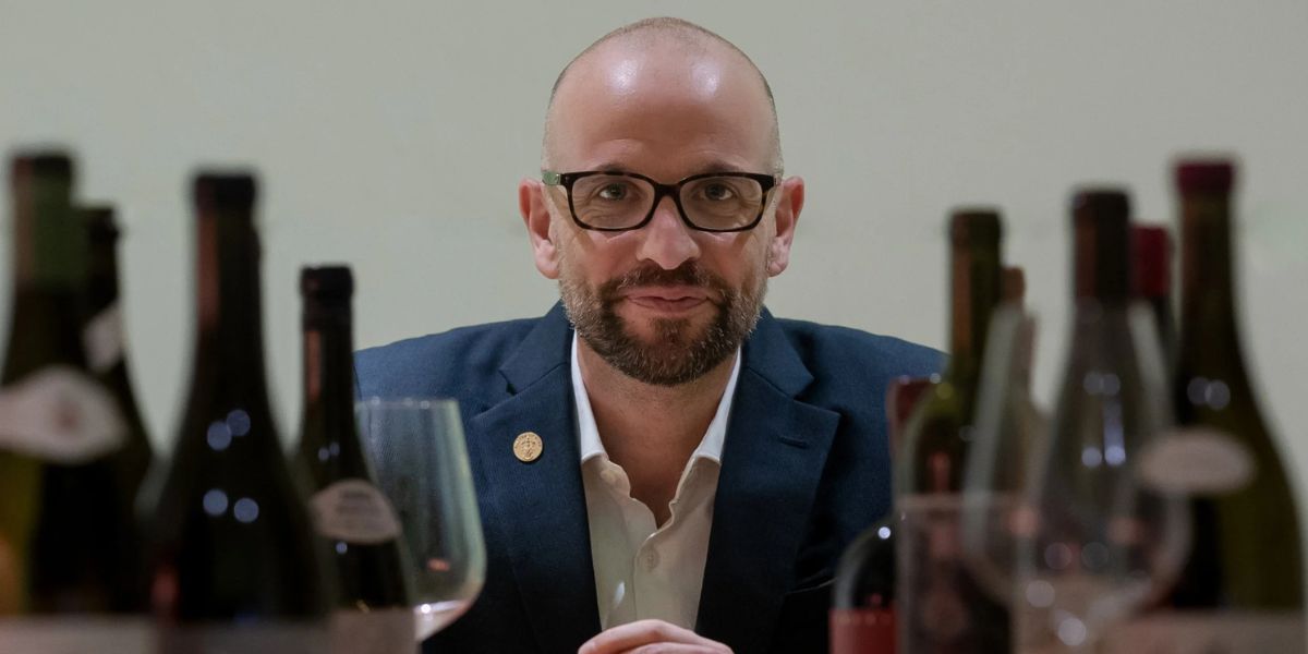 richard hemming mw surrounded by wine bottles