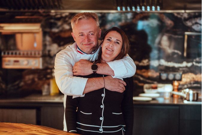 Fabien and Rachel Lefebvre hug inside Cocagne restaurant